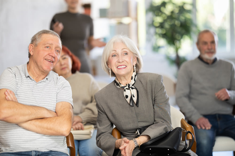 Elderly people listening and talking to each other during group presentation