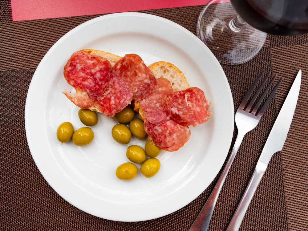 Tapas sandwich with pork sausage and olives