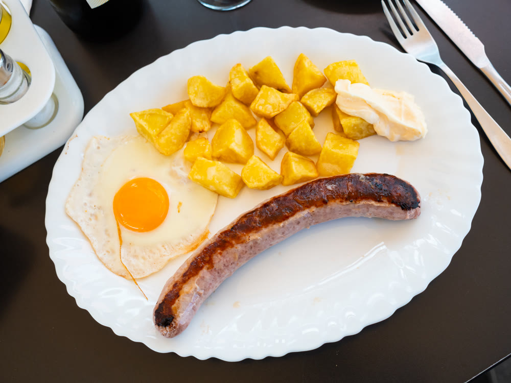 Fried Butifarra sausage with potatoes and eggs