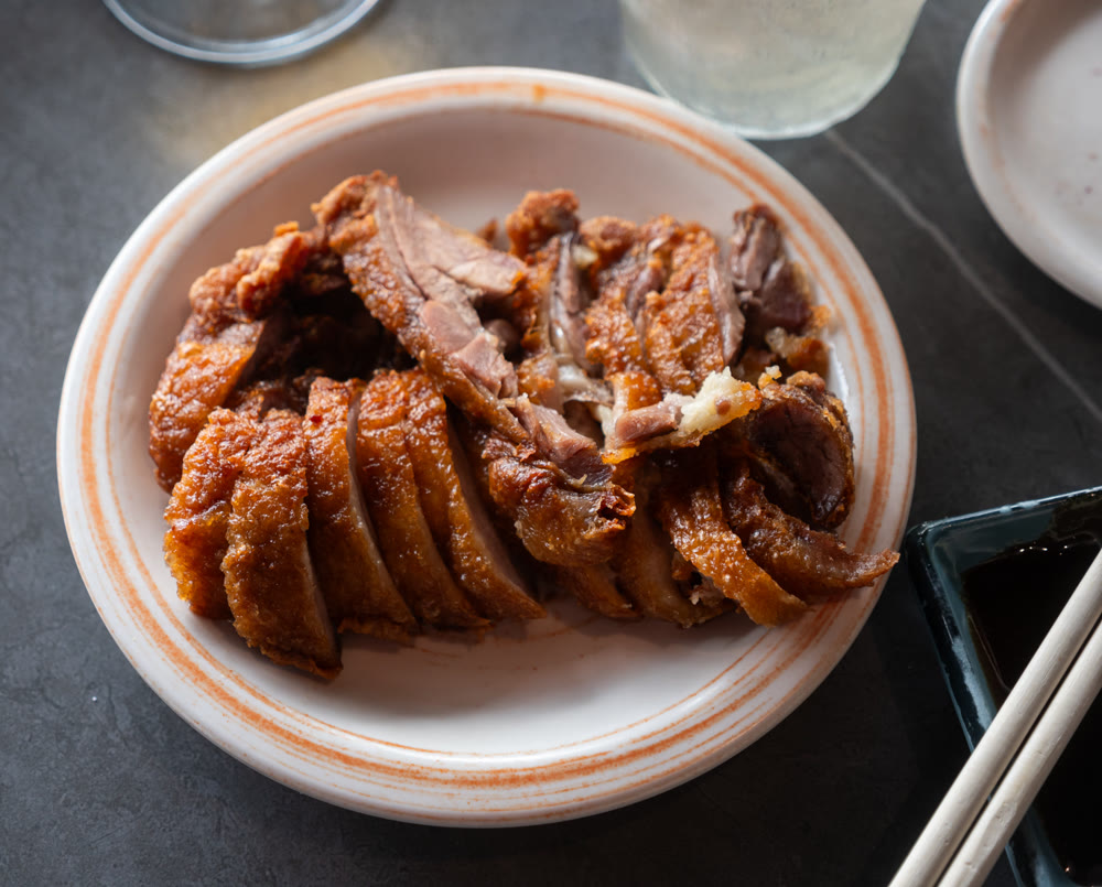 Appetizing pieces of baked duck breast are served with spicy sauce and decorated with white sesame seeds