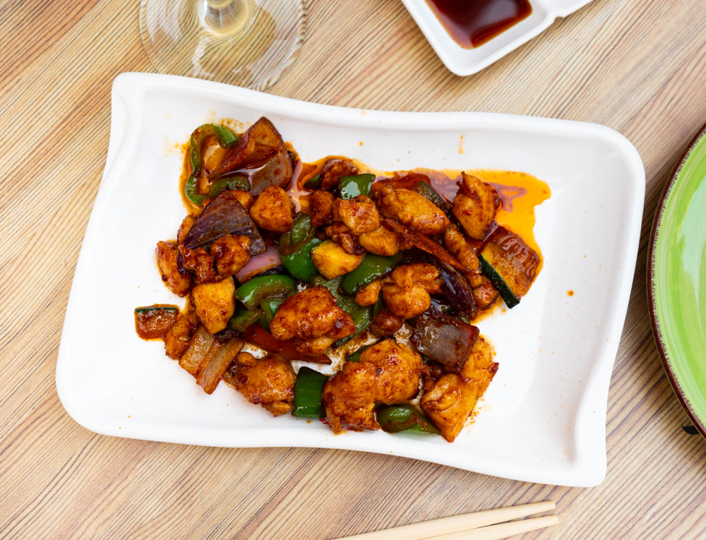 Tasty chicken pieces in in satay sauce with stewed eggplant and peppers