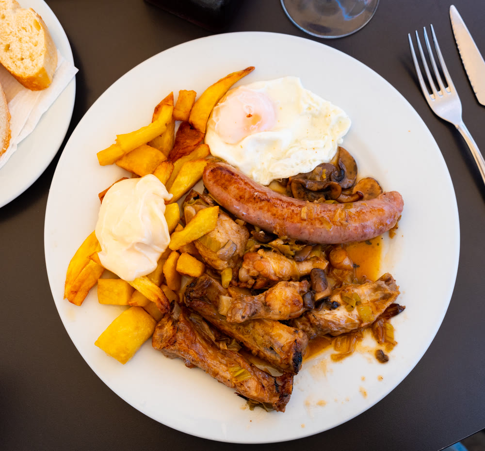 Stewed meat, chicken drumstick, sausages with mushrooms and fried eggs