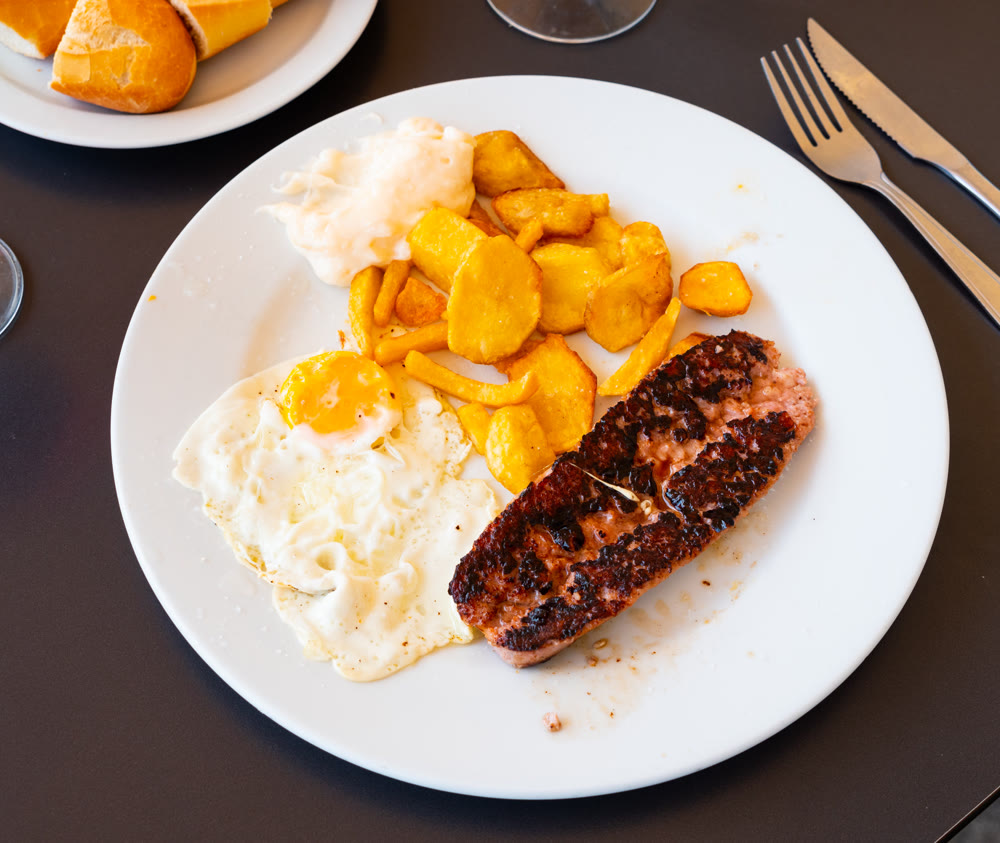 Fried Butifarra sausage with potatoes and eggs