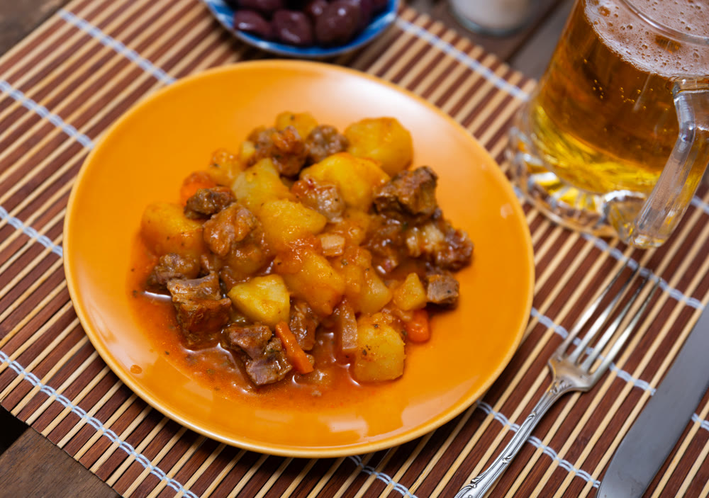 Stewed veal in sauce on a plate with vegetables