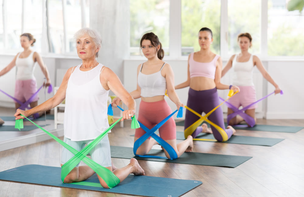 Elderly woman exercises with pilates band