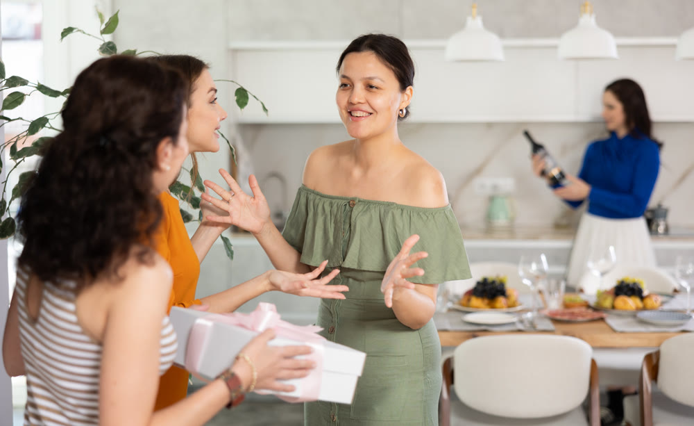 Asian woman greeting friends bringing gift for home party