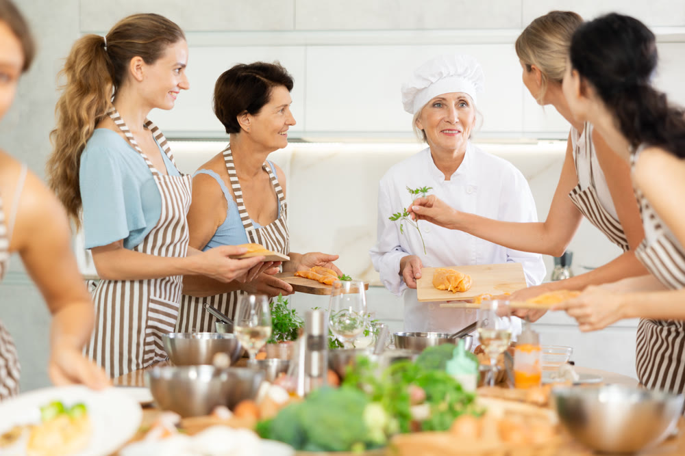 Mature female cook holding cutting board with raw chicken