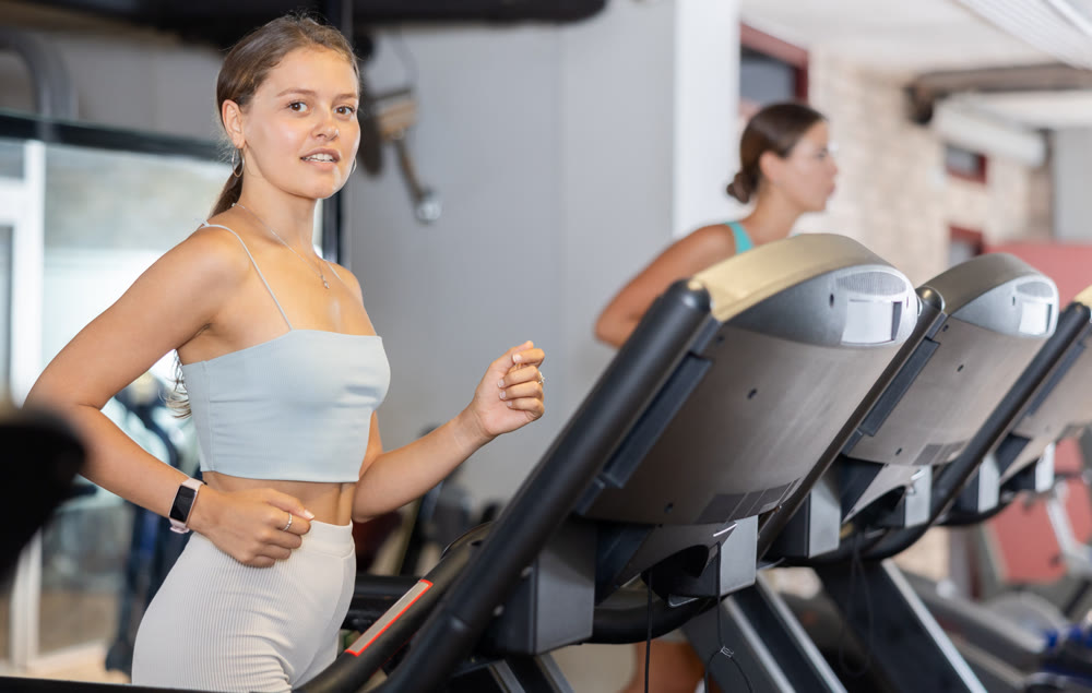 Young woman exercising on treadmill in gym