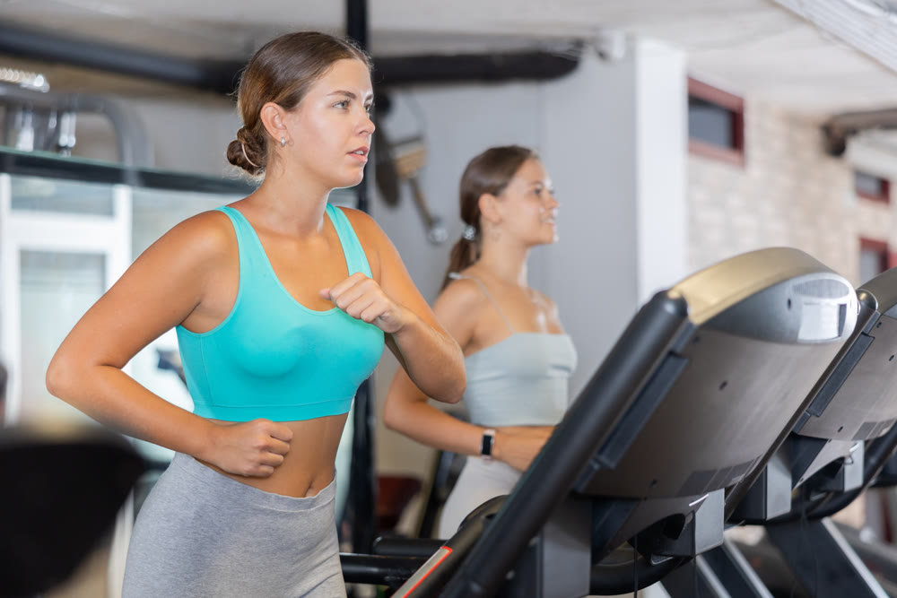 Young woman exercising on treadmill in gym
