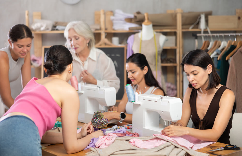 Multigenerational group of women enjoying sewing class in workshop