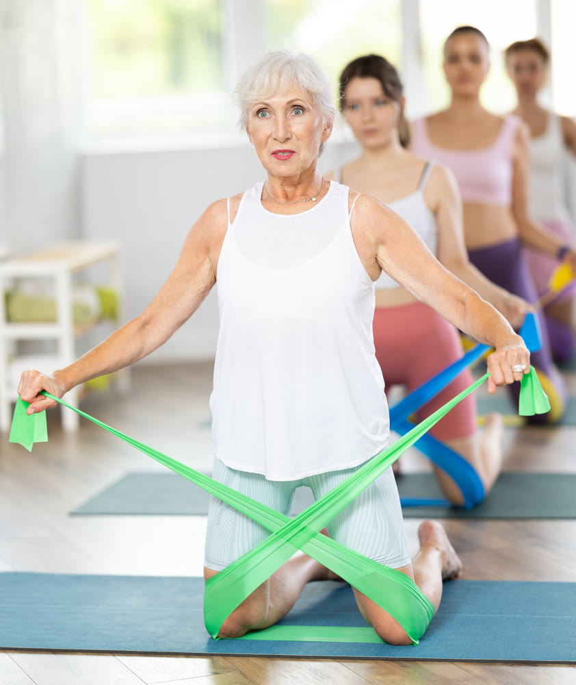 Elderly woman exercises with pilates band