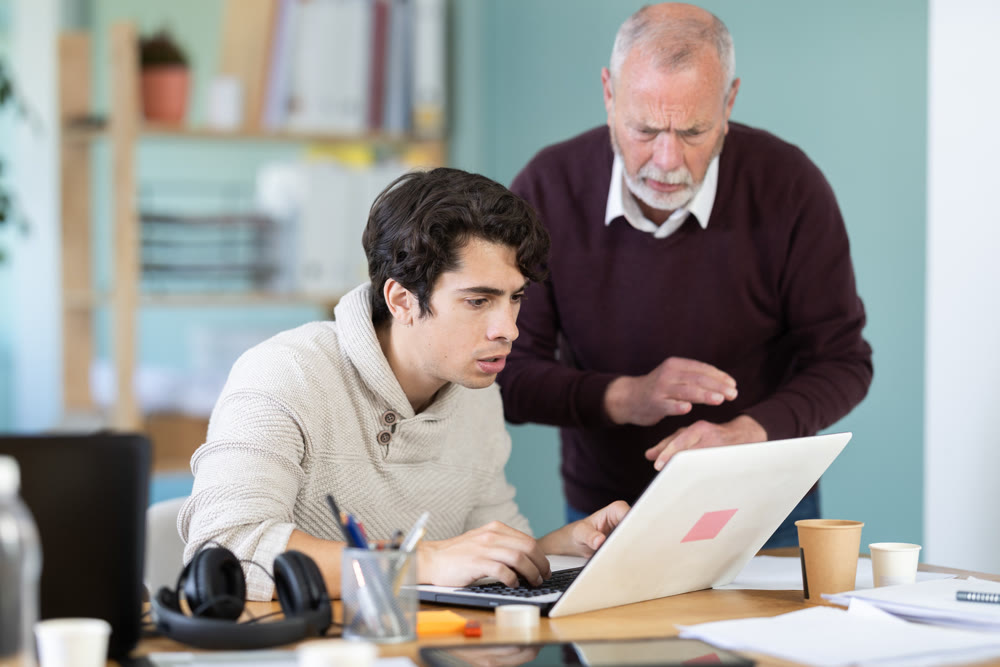Frustrated and discouraged men in front of laptop in office workplace