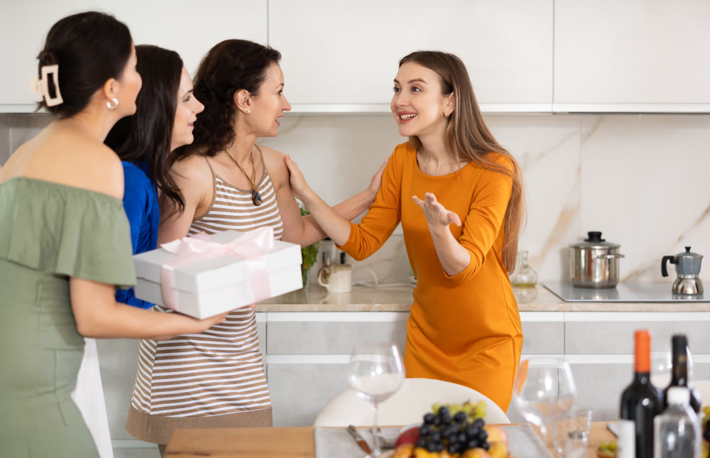 Group of women greeting each other and giving gift