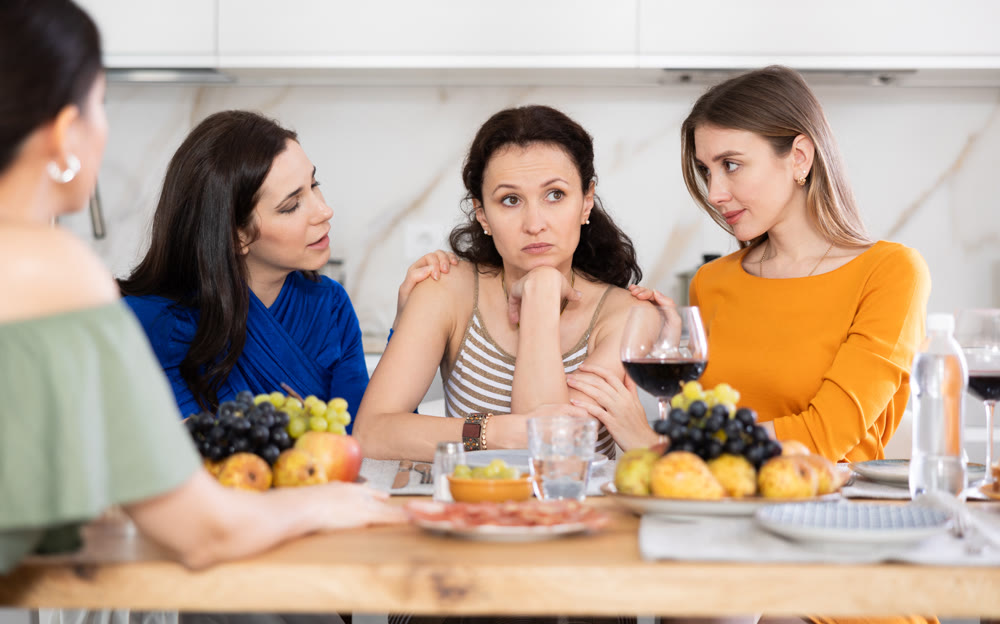 Group of female friends calming adult woman
