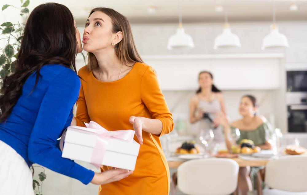 Group of women greeting each other and giving gift