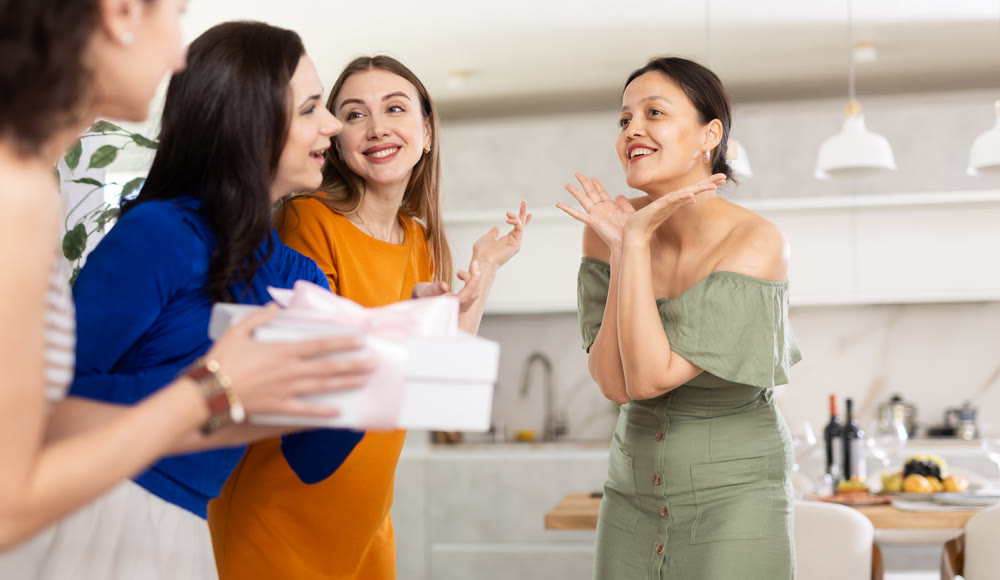 Group of women greeting each other and giving gift