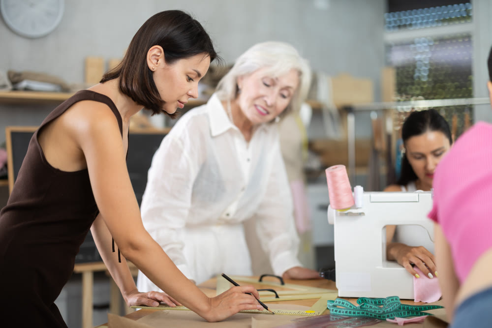 Young woman drawing on paper during dressmaking classes