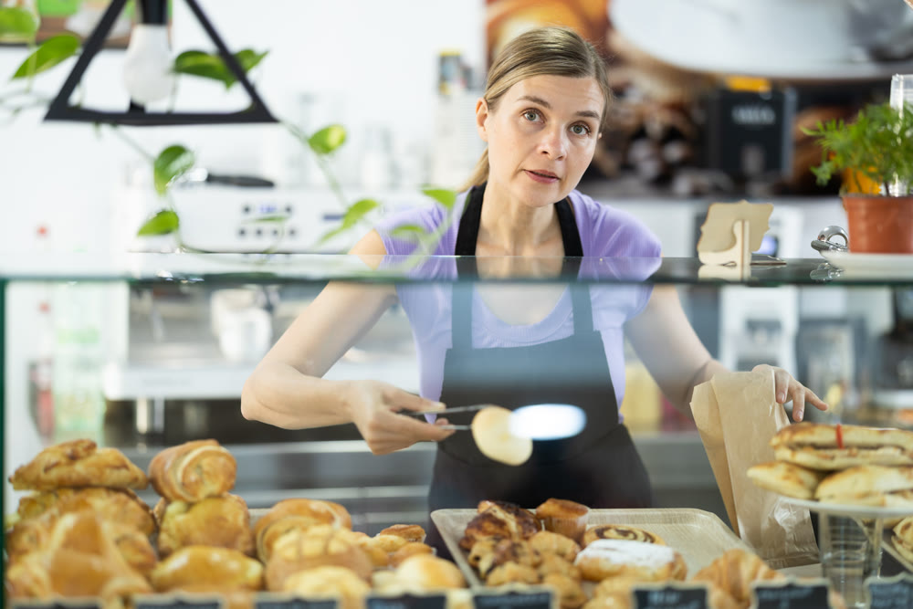 Female cafe employee offers to buy baked goods