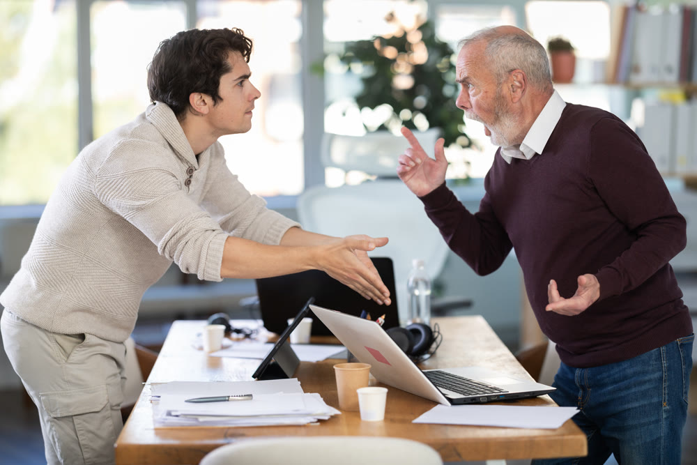 Quarrel between two managers - an elderly man and young man shout at each other, dissatisfied with their work