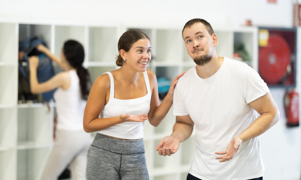 Young man and woman talking in locker room