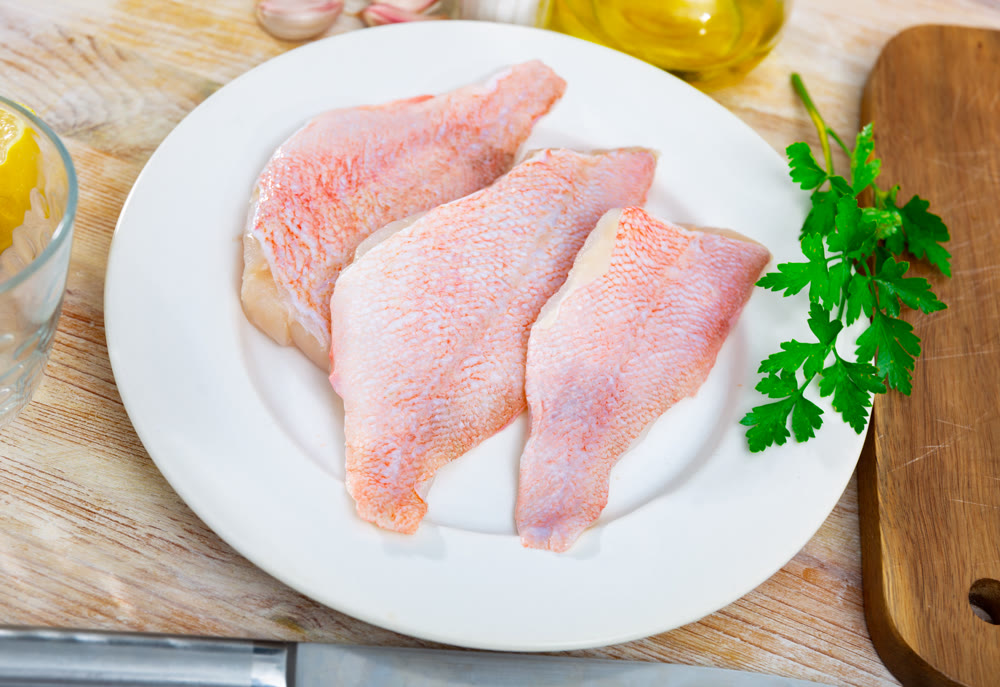Raw rockfish fillet with condiments, cooking ingredients