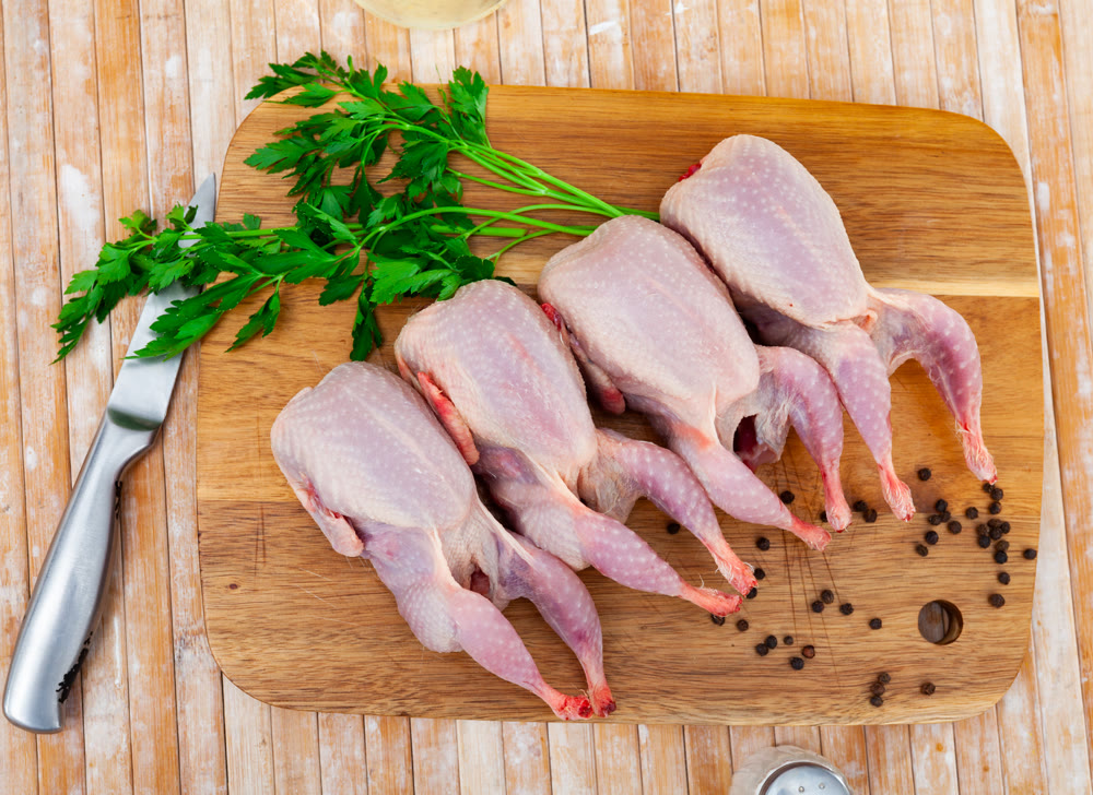 Fresh raw meat quails ready for cooking on slate board