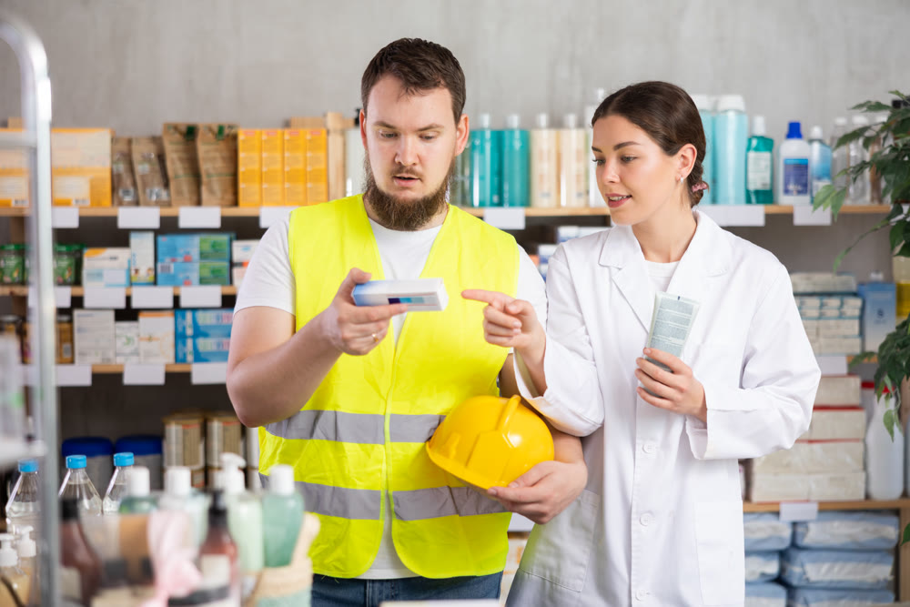 Laboring man builder buys gel for burns at pharmacy, consulting with girl pharmacist