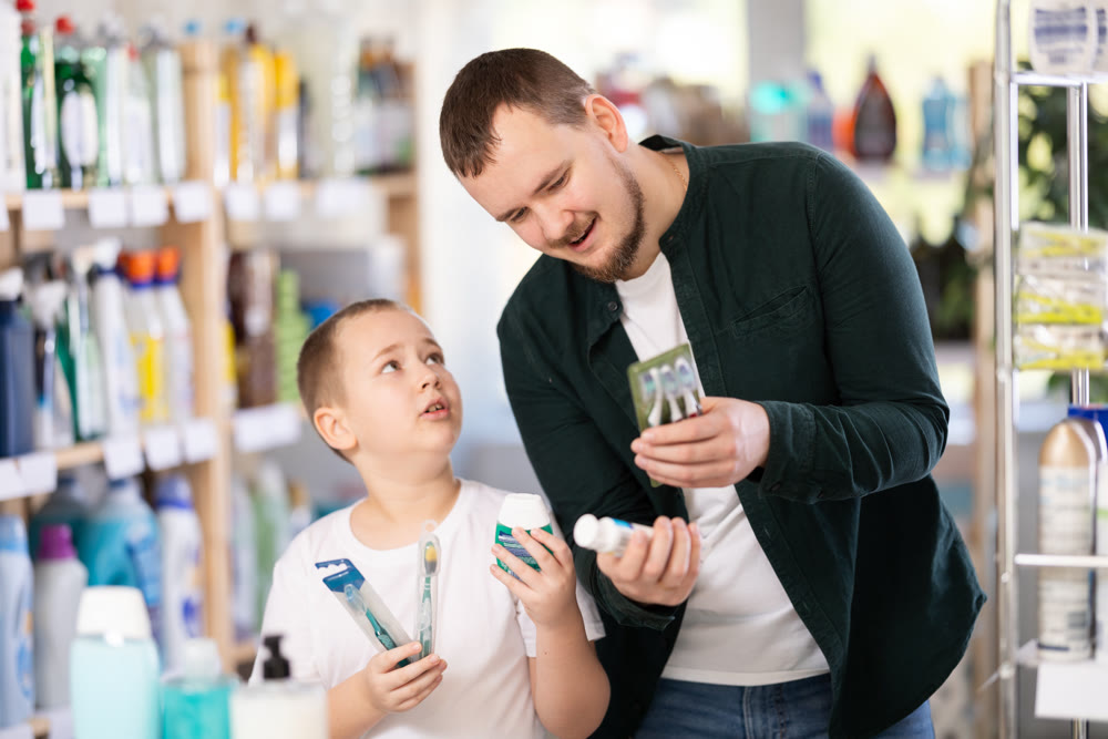 Man and boy choosing toothbrush in store