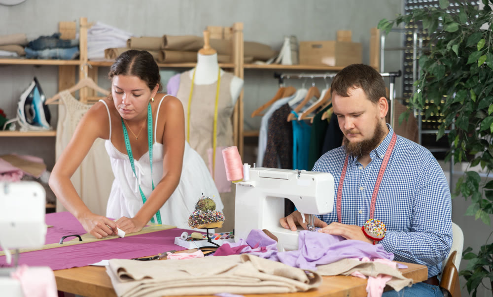 Male dressmaker discussing textile with girl