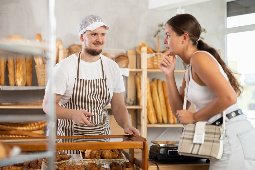 European woman visited bakery, communicates with male seller