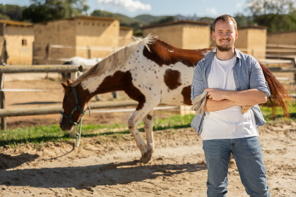 Young man posing in horse paddock