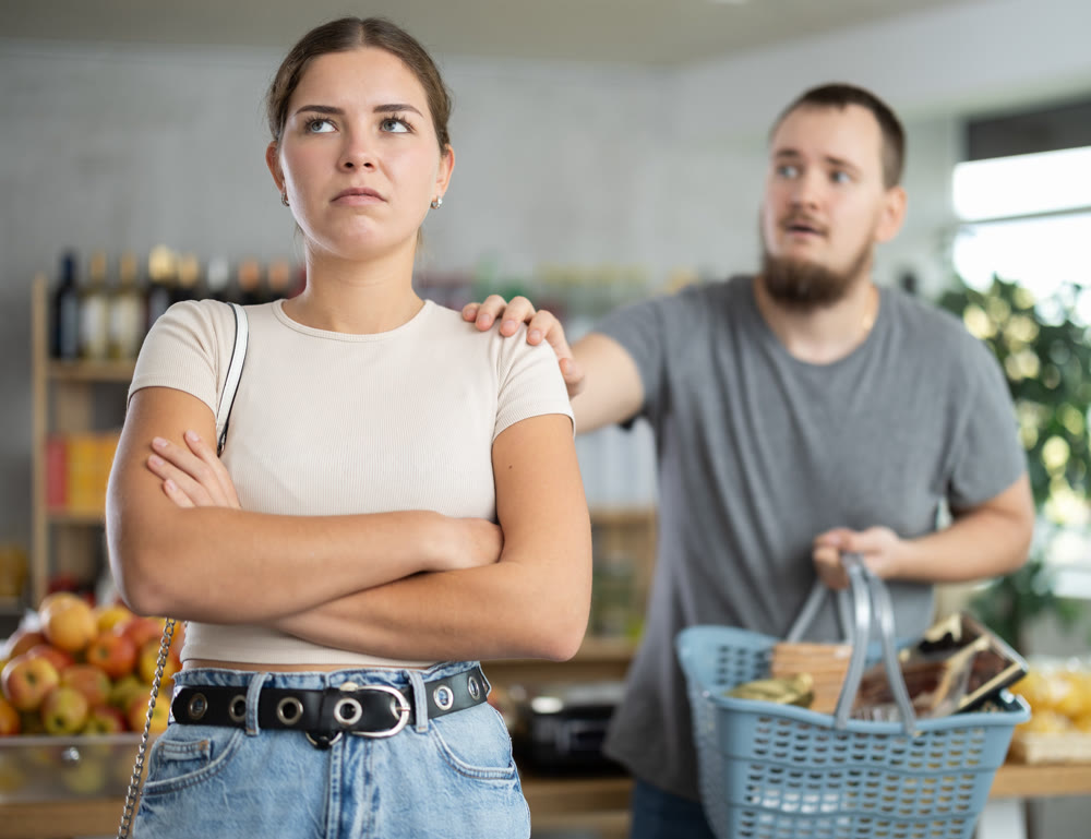 Angry girl turned away from husband during quarrel, he want to make peace after quarrel, calm wife