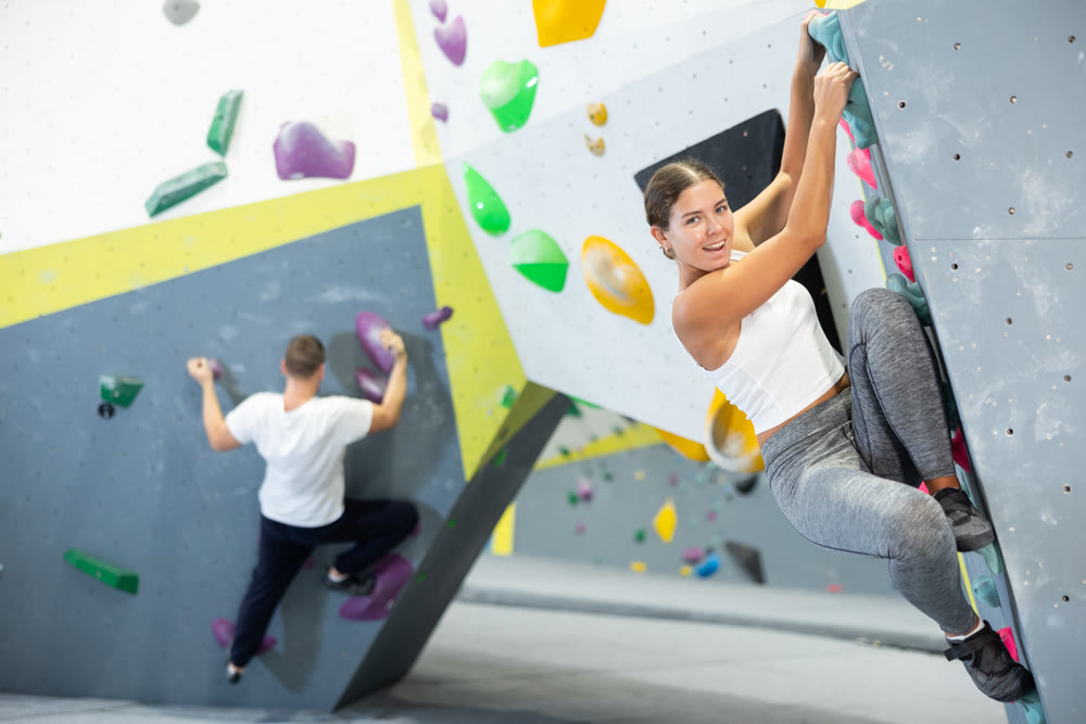 Young woman practicing rock climbing on climbing wall