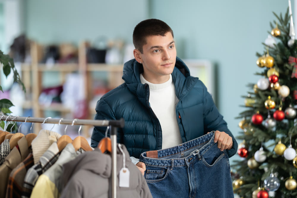 Young man choosing jeans in clothing store