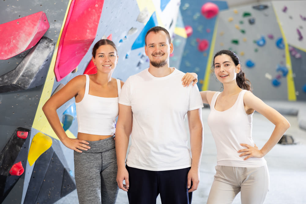 Portrait of three athletic people in climbing gym