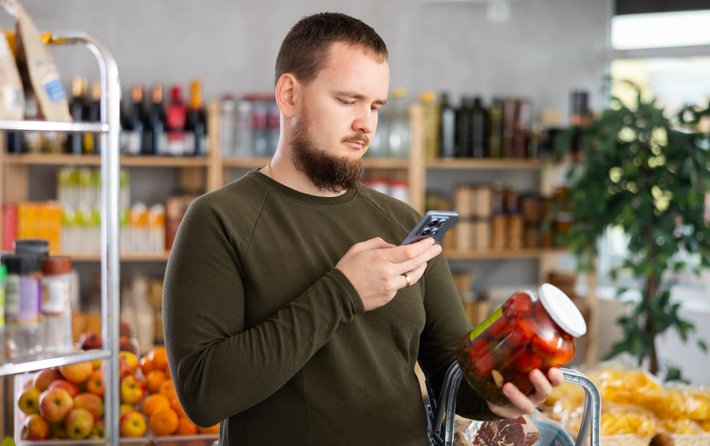 Man scanning barcode on pickled tomatoes
