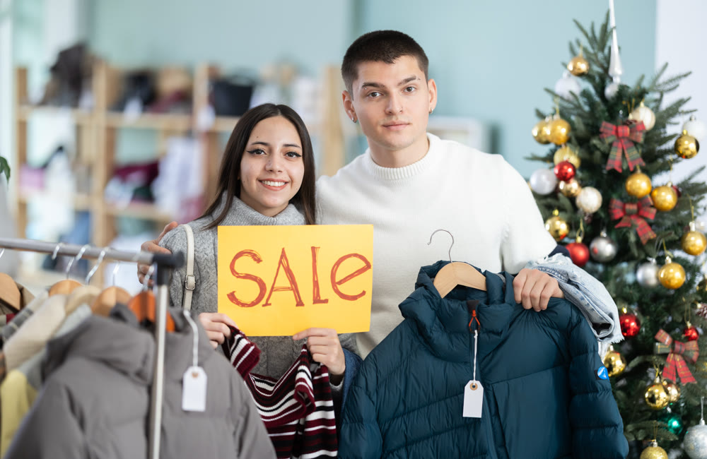 Guy and girl couple with poster announces mega New Year sale