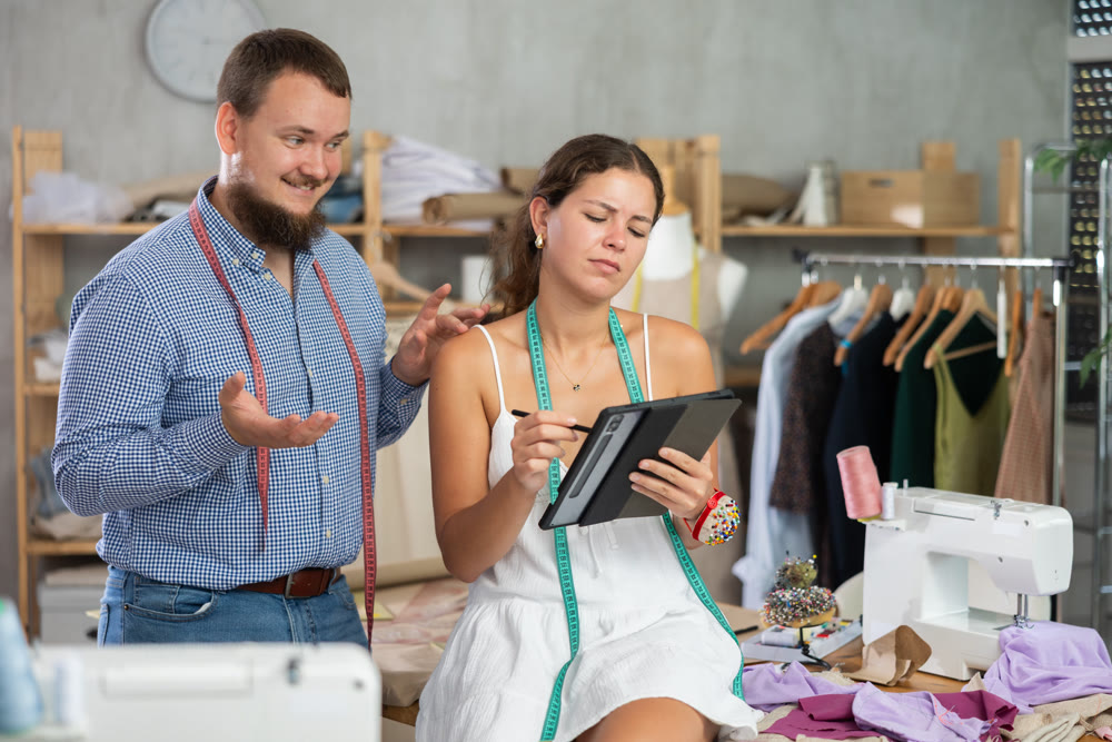 Young female dressmaker harasses male tailor