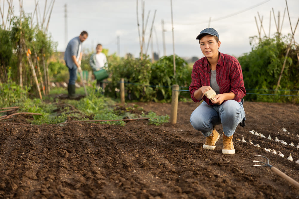 Female farmer planting seeds in the garden