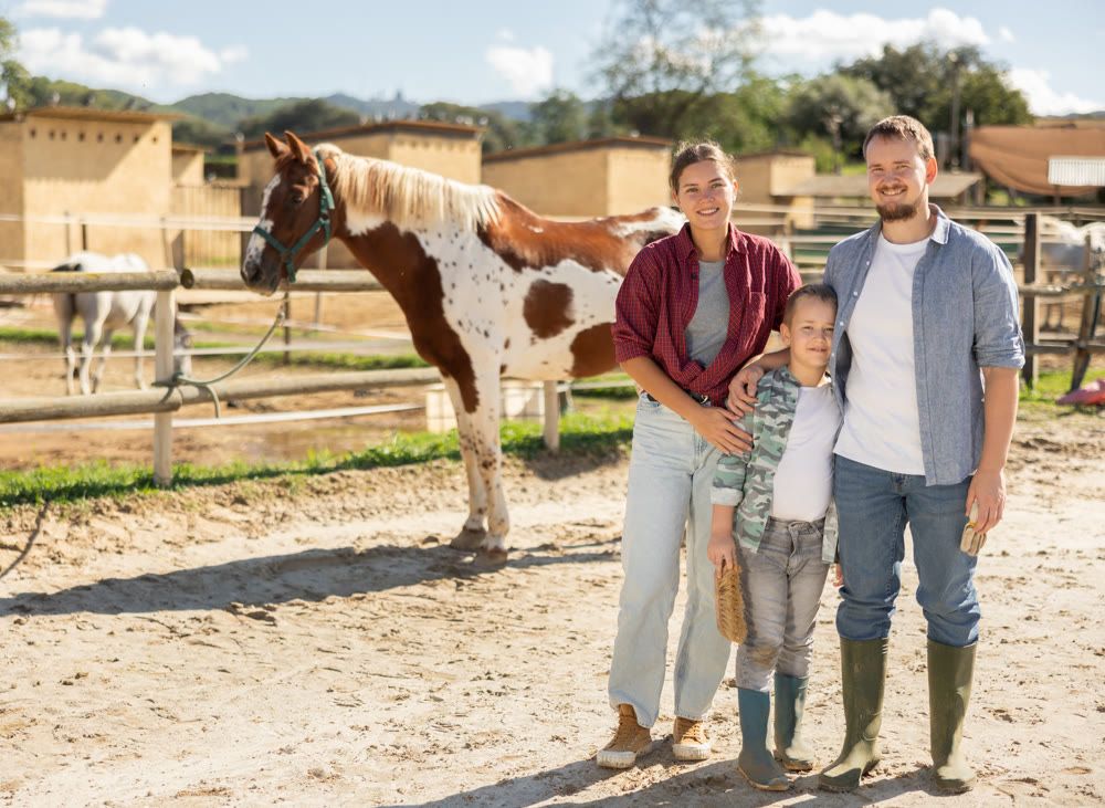 Woman man and boy in horse paddock