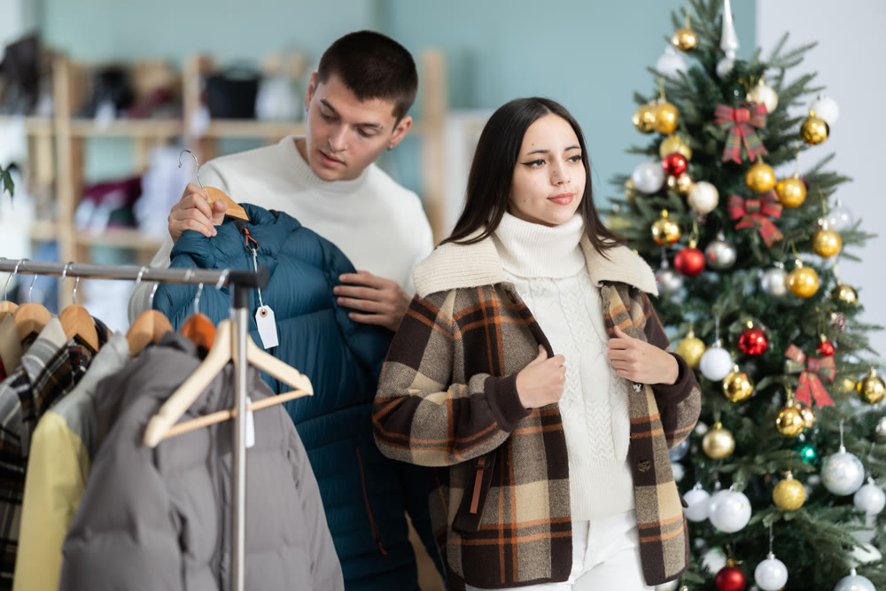 Young woman and her boyfriend trying on jacket