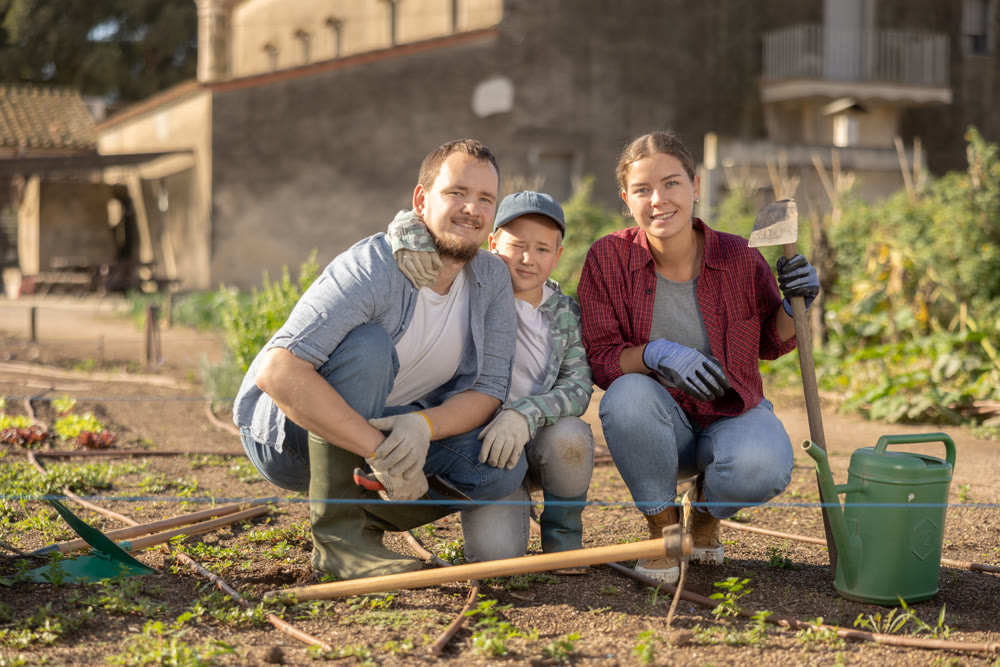 Family of farmers standing in the garden
