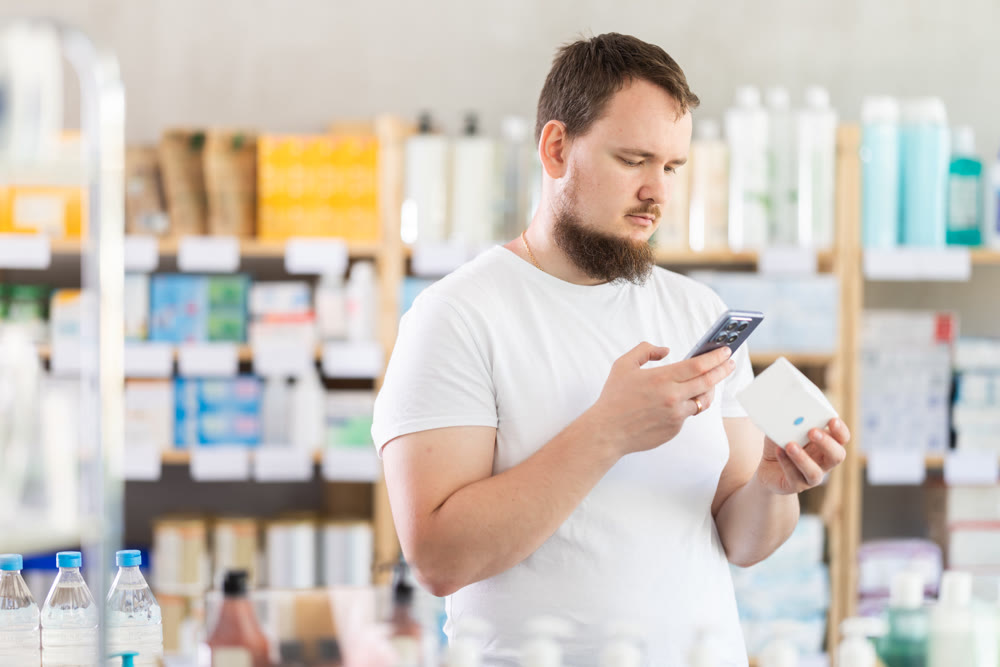 Young man scanning qr code of pills