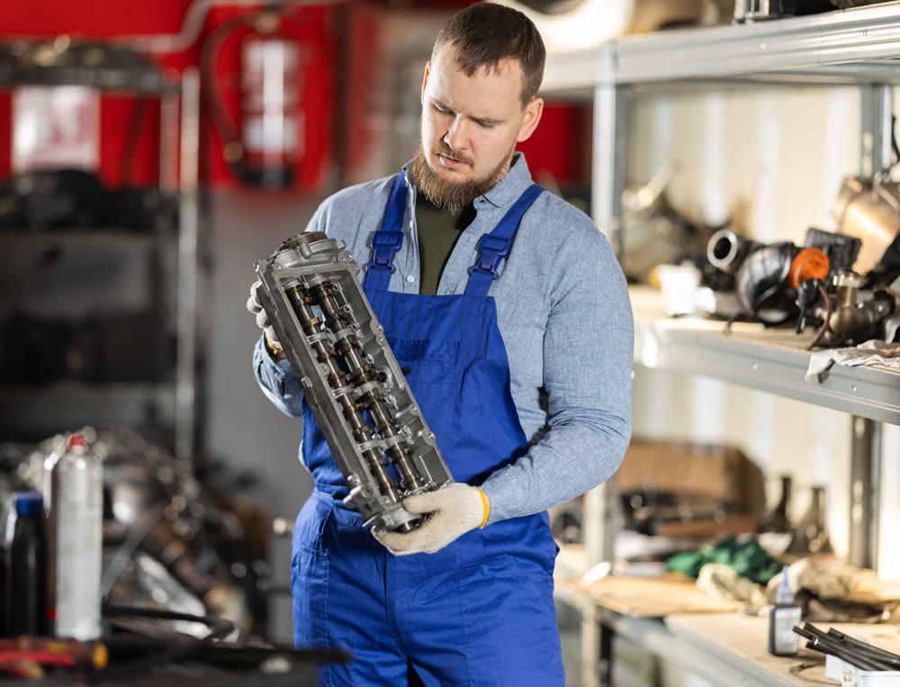 Man professional auto mechanic repairing car engine in garage