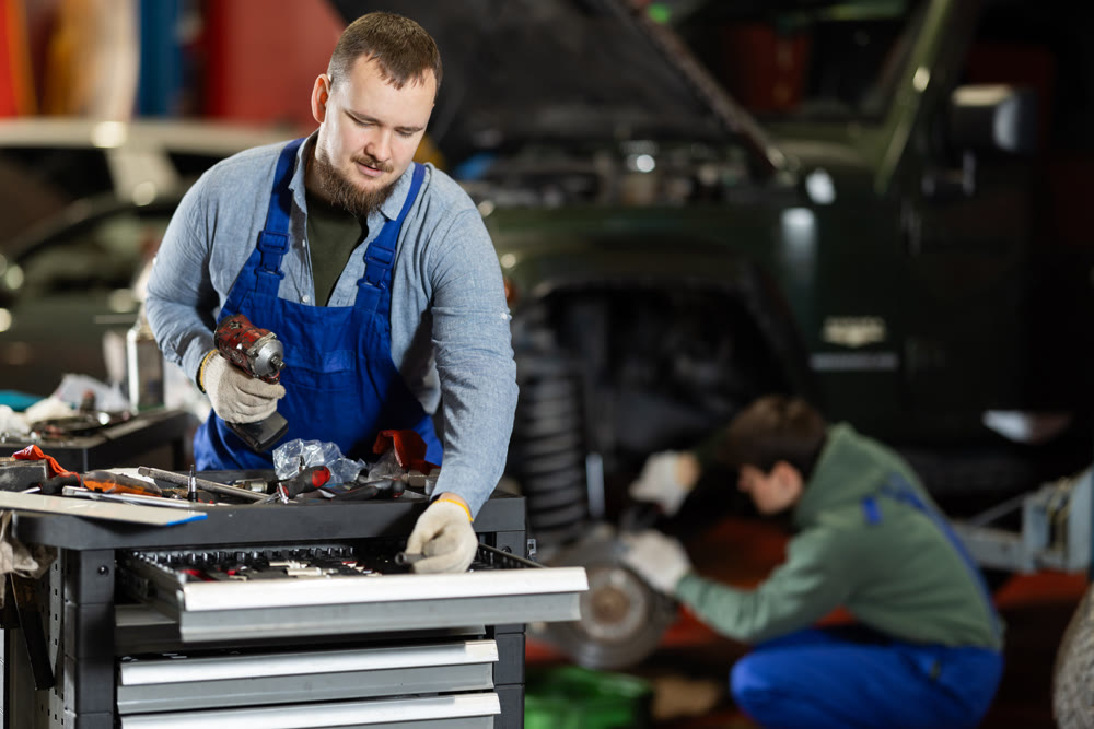 Portrait of car mechanic in overalls working in garage of car repair shop