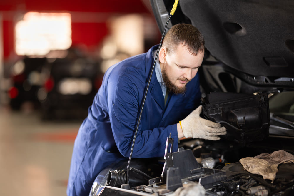 man checks the condition of the engine and oil under the hood