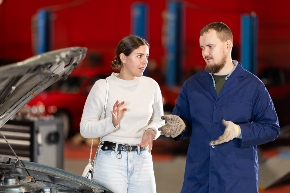Woman Consulting Male Mechanic About Car