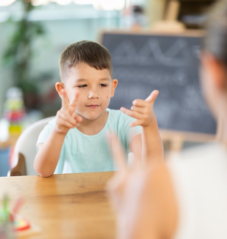 Child psychologist shows certain number of fingers, and boy repeats