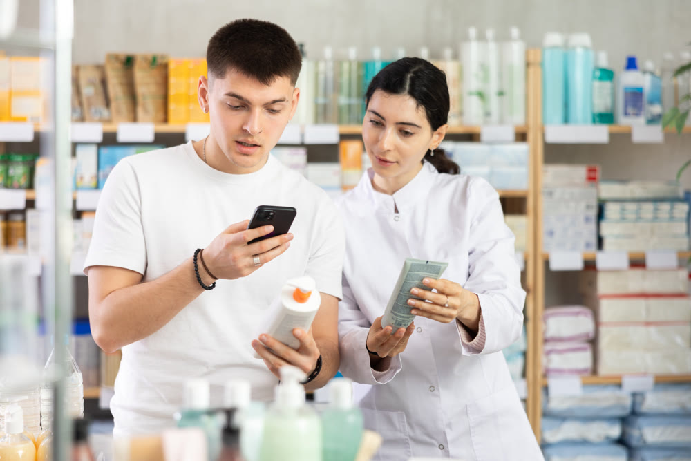 Man scans QR code on box skin cream label. Female pharmacist offers to choose right gel