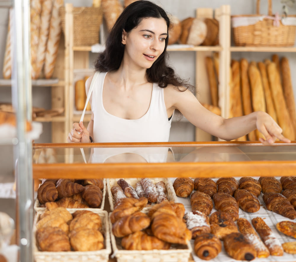 Young woman choosing pastries in bakery